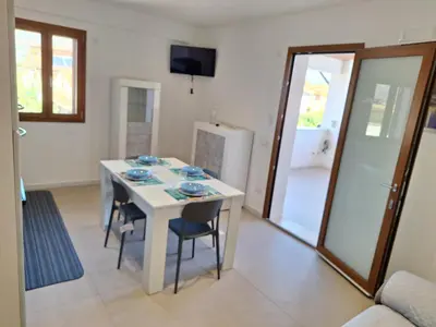 a dining room with a white table and chairs at La Marina Pool Villa in Trappeto