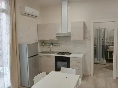 a kitchen with white appliances and a white table and chairs at Butterfly Apartments in Palermo
