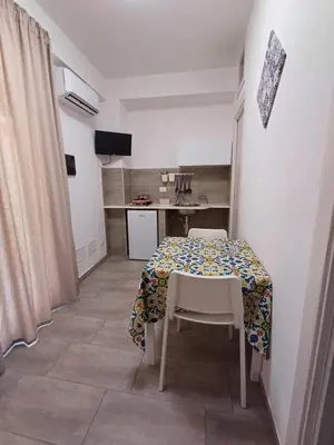 a small kitchen with a table and a table and chairs at Studio 23 in Partinico