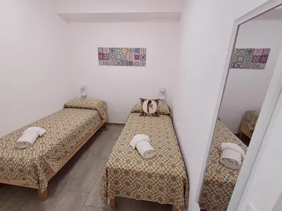a room with two beds and a mirror at Studio 23 in Partinico