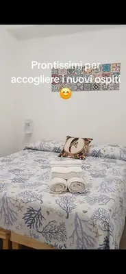 a bed with a blue and white blanket and a frisbee on it at Studio 23 in Partinico