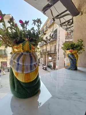 two vases sitting on a table with flowers in them at Il Pirtuso in Palermo