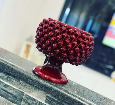 a red vase filled with cherries sitting on a bench at Borbon Home luxury rooms & SPA in Palermo