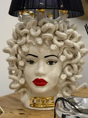 a statue of a woman with curly hair with a lamp at Borbon Home luxury rooms & SPA in Palermo