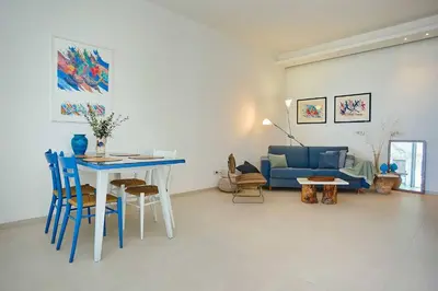 a living room with a table and a blue couch at Villa Marinjo in Alcamo