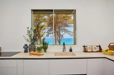 a kitchen counter with a window above a sink at Villa Marinjo in Alcamo