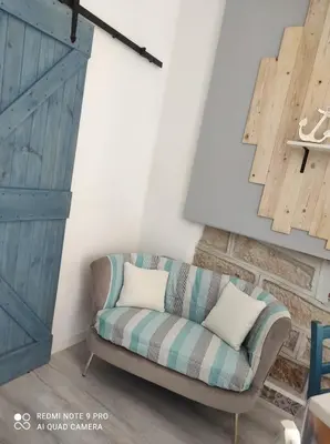 a living room with a couch and a door at Summer House in Isola delle Femmine