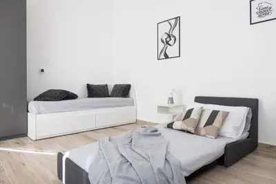 a white bedroom with a bed and a couch at Uditore Mini Apartment in Palermo