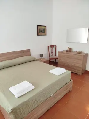 a bedroom with a bed and a desk and a chair at Villa Cetti a Mondello in Palermo