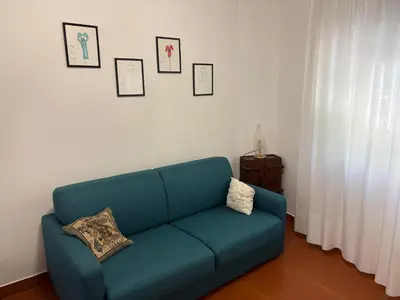 a blue couch in a living room with pictures on the wall at Villa Cetti a Mondello in Palermo