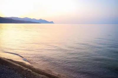 a beach with the sun rising over the water at Casa vacanze CaMi in Alcamo