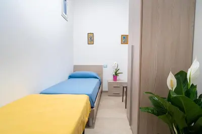 a bedroom with two beds with yellow and blue sheets at Casa vacanze CaMi in Alcamo