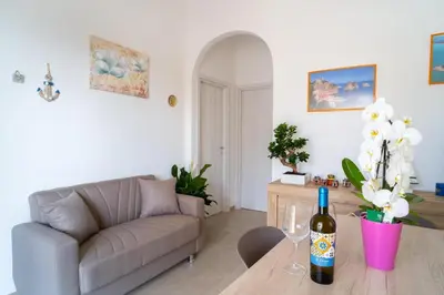 a living room with a couch and a bottle of wine on a table at Casa vacanze CaMi in Alcamo