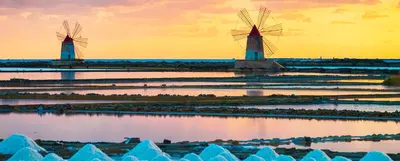 two windmills in the water at sunset at Casa vacanze CaMi in Alcamo