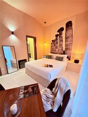 a hotel room with two beds and a table at Bìfara Rooms in Palermo