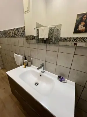 a bathroom with a white sink and a mirror at Don Bosco Suite in Palermo