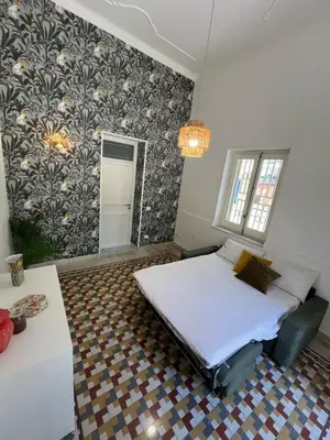 a bedroom with a bed and a patterned wall at Don Bosco Suite in Palermo