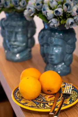 a plate of oranges on a table with a vase at Al Capo Suite Home in Palermo