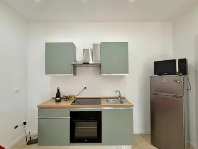 a kitchen and dining room with a table and a refrigerator at Il Capriccio in Palermo