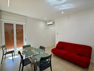 a living room with a red couch and a table at Il Capriccio in Palermo