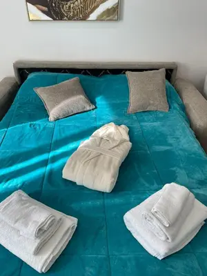 a blue bed with two white towels on it at Gold Rooms in Carini