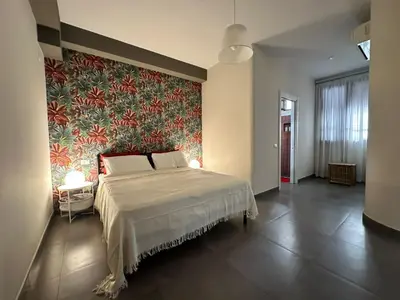 a bedroom with a large bed and a colorful wall at Matteotti 17 Easy in Cinisi