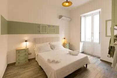 a bedroom with a white bed with towels on it at Aromarìa Palace in Palermo