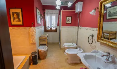 a bathroom with a sink and a toilet and a mirror at Casa Leandra in Casteldaccia