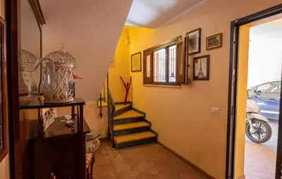 a hallway with stairs in a house with a motorcycle at Casa Leandra in Casteldaccia