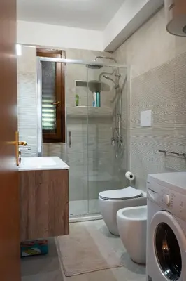 a bathroom with a shower toilet and a washing machine at Villa Lipari in Castellammare del Golfo