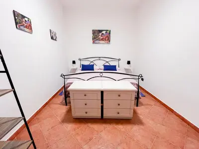 a bedroom with a bed in a white wall at Kemonia home in Palermo