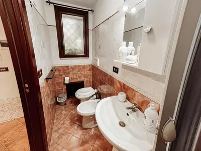a bathroom with a white sink and a toilet at Kemonia home in Palermo