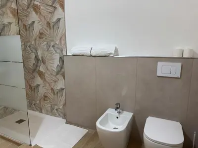 a bathroom with a white toilet and a sink at Caltur B&B in Palermo