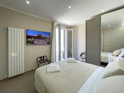 a bedroom with a large white bed and a mirror at Settimo Cielo al Massimo Guest House in Palermo