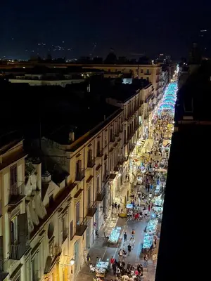 a city street at night with a crowd of people at Settimo Cielo al Massimo Guest House in Palermo