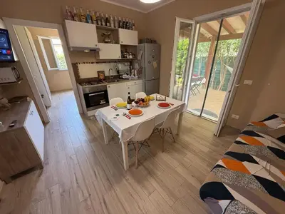 a kitchen with a white table in a room at Villetta Sunrise by Holiday World in Lascari
