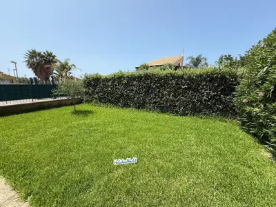 a yard with a sign in the grass at Villetta Sunrise by Holiday World in Lascari