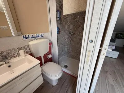 a bathroom with a toilet and a sink and a shower at Villetta Sunrise by Holiday World in Lascari
