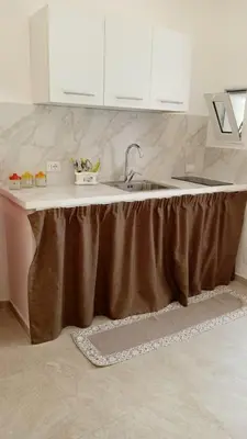 a kitchen with a sink with a brown skirt on it at Scialari - Palermo Holiday Home in Palermo