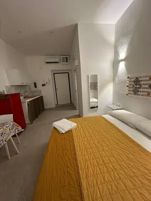 a bedroom with a large bed with a yellow blanket on it at Scialari - Palermo Holiday Home in Palermo