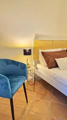 a bedroom with a bed and a chair and a lamp at Domus Dea in Mondello