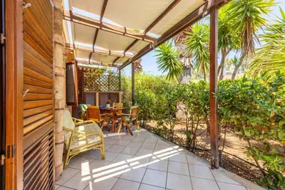 a patio with a table and chairs under a pergola at Acquamarina 24 in San Vito lo Capo