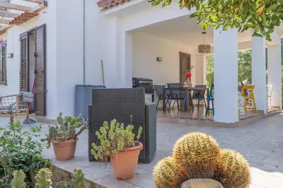 a patio with potted plants and a house at Villa a due passi dal mare 