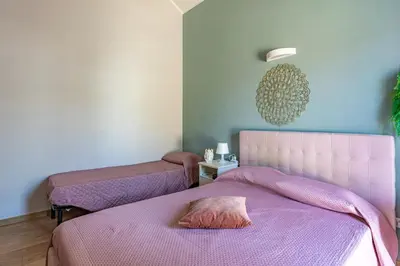 two beds in a room with purple sheets at Villa a due passi dal mare 