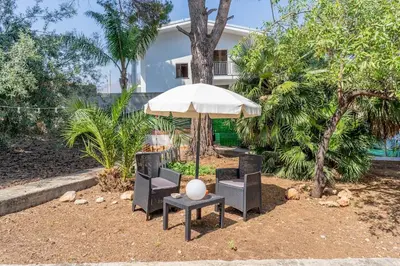 a table and two chairs and an umbrella at Villa a due passi dal mare 
