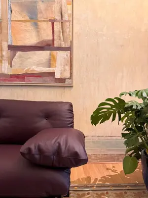 a couch in a room with a painting and a plant at Gilded Age Luxury dream apartment historic center in Palermo