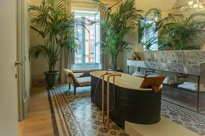 a bathroom with a tub and potted plants at Gilded Age Luxury dream apartment historic center in Palermo