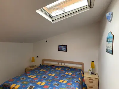 a bedroom with a bed and a skylight at Villa Maria in Campofelice di Roccella