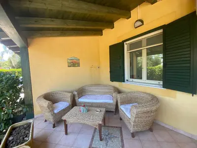 a patio with two wicker chairs and a table at Villa Maria in Campofelice di Roccella