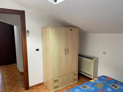a bedroom with a bed and a wooden cabinet at Villa Maria in Campofelice di Roccella